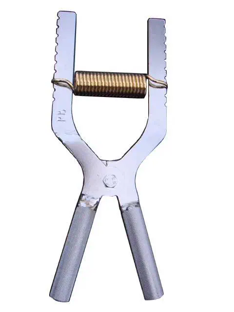 Metallinen puristin, jousimekanismi.