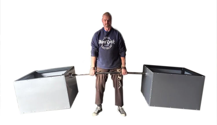 Mies nostaa raskasta painoa.