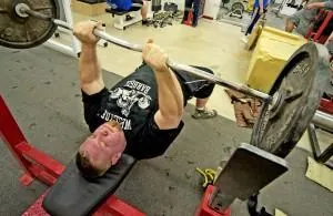 Täysimittainen EZ mutkatanko 2 Mies nostaa painoja penkillä